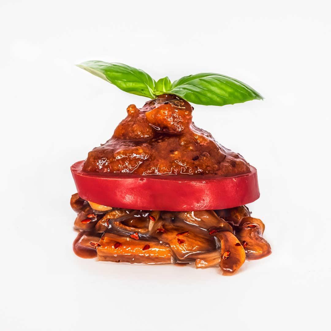 Fermentierte Shiitake mit Paprika und Red Umami Paste. Basilikumblatt als Deko